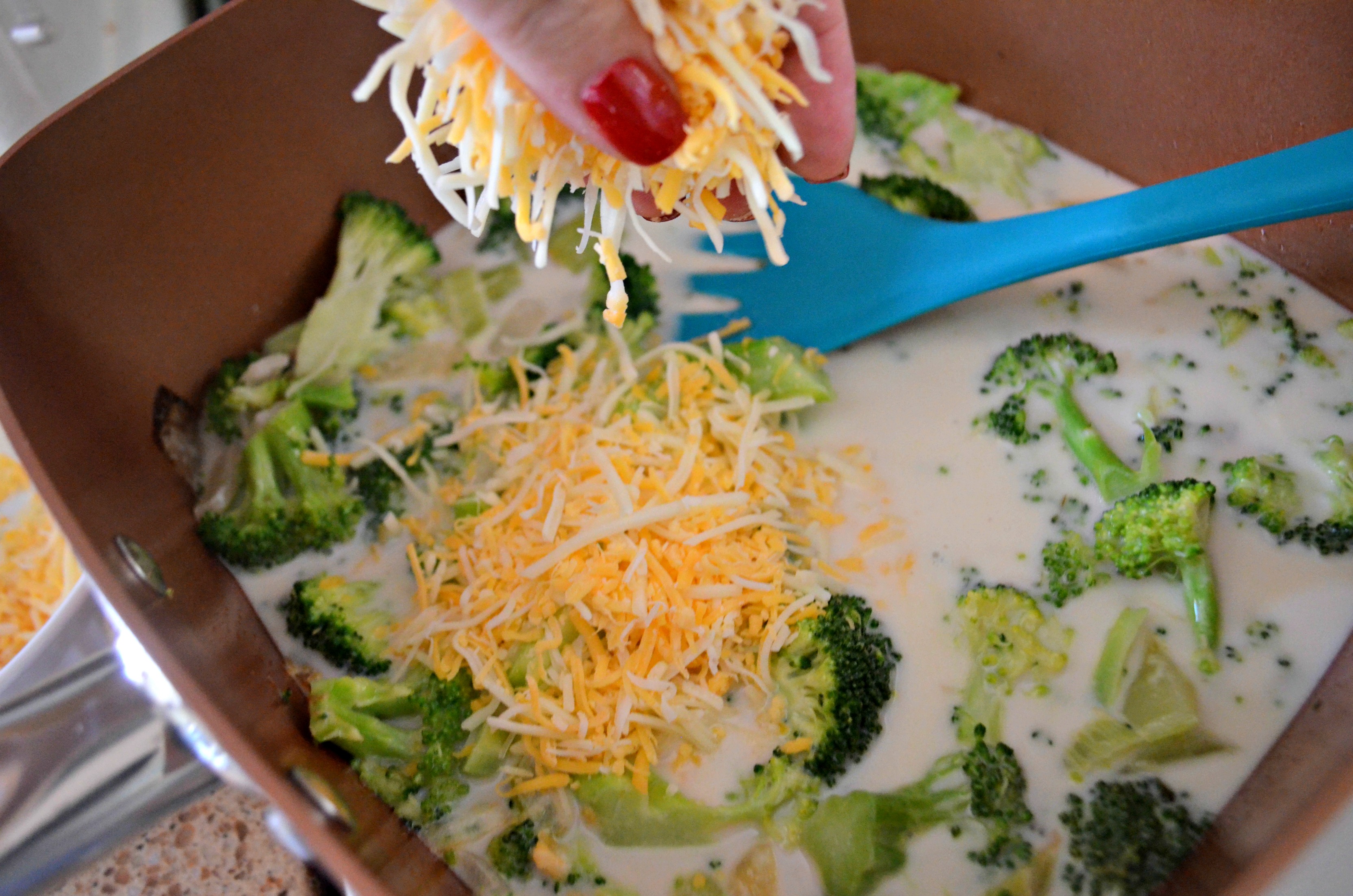 adding cheese to broccoli cheese soup