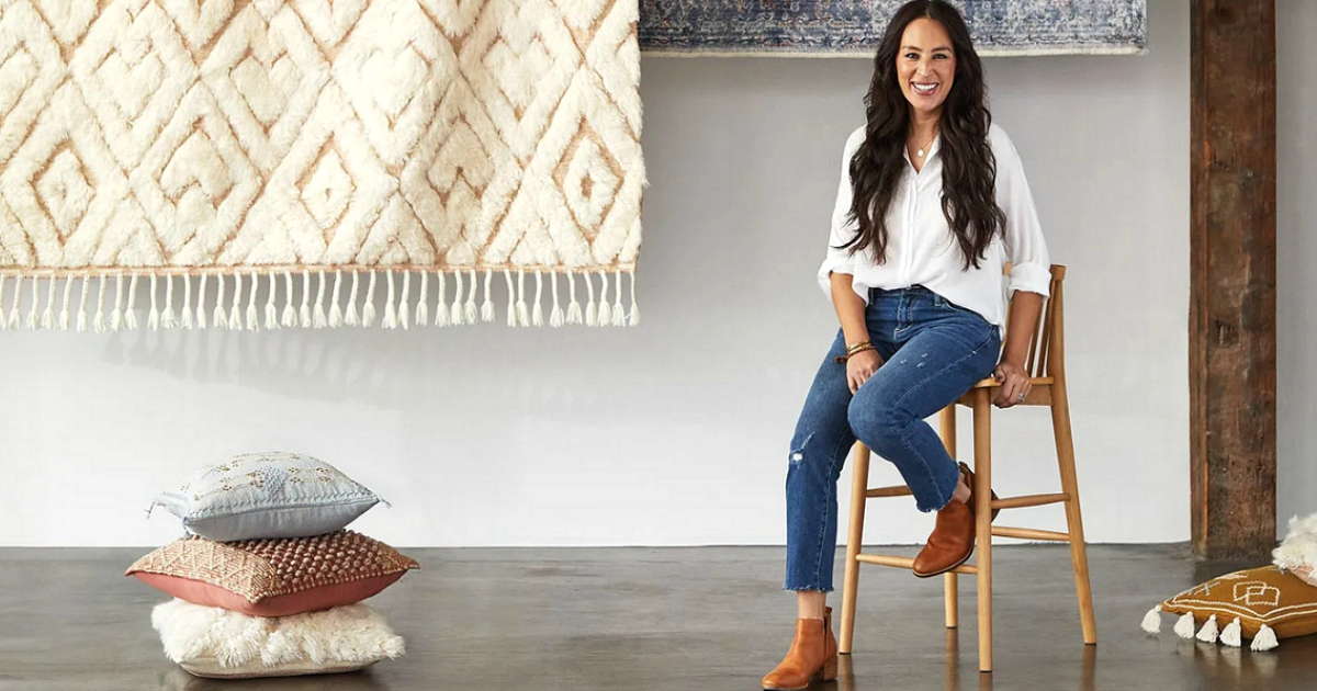 Joanna Gaines sitting next to pillows and rugs