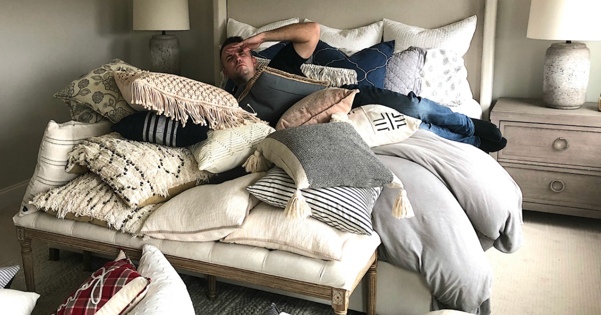 Eddie with tons of throw pillows on bed