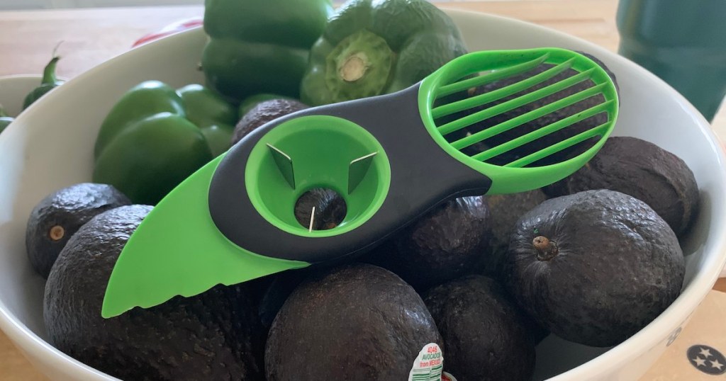 bowl of avocados and peppers with an green knife peeler sitting on top
