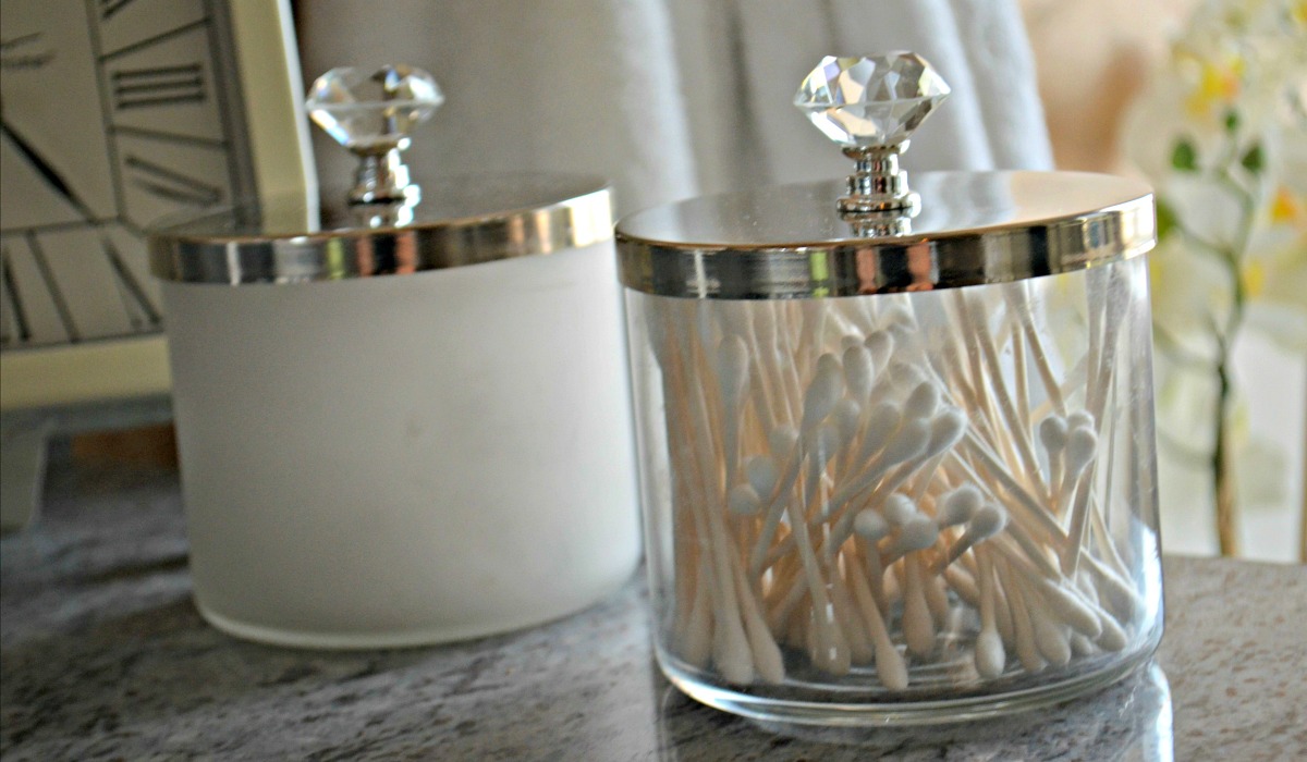 repurposed candle jars being used for bathroom vanity storage