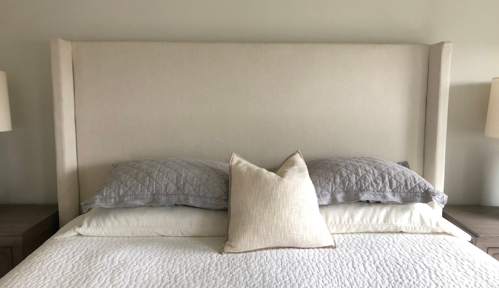 bed with five pillows gray and cream colored