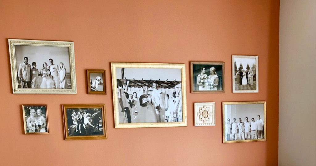 orange gallery wall with various sizes of picture frames