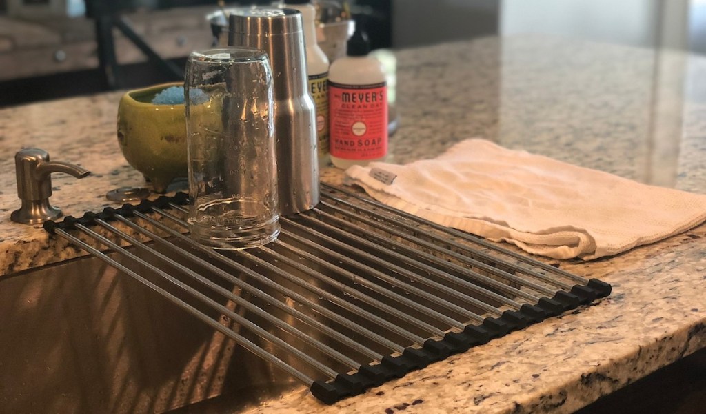 metal drying rack sitting over kitchen sink with two wet cups sitting on top