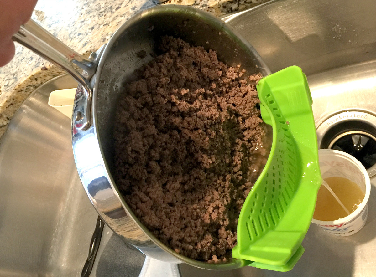 green meat strainer clipped onto a cooking pan