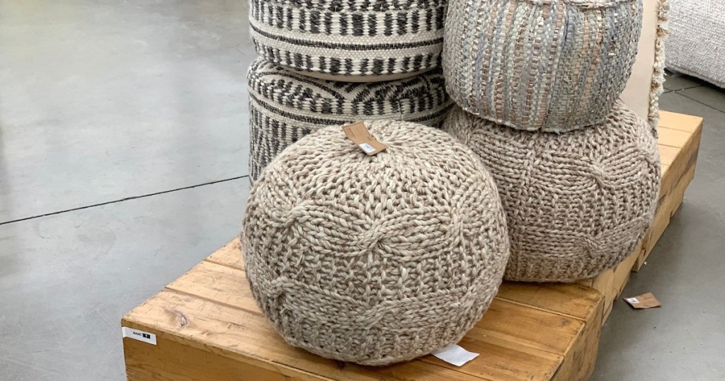 knit sweater and abstract wool ottomans sitting on a wood pallet on the floor