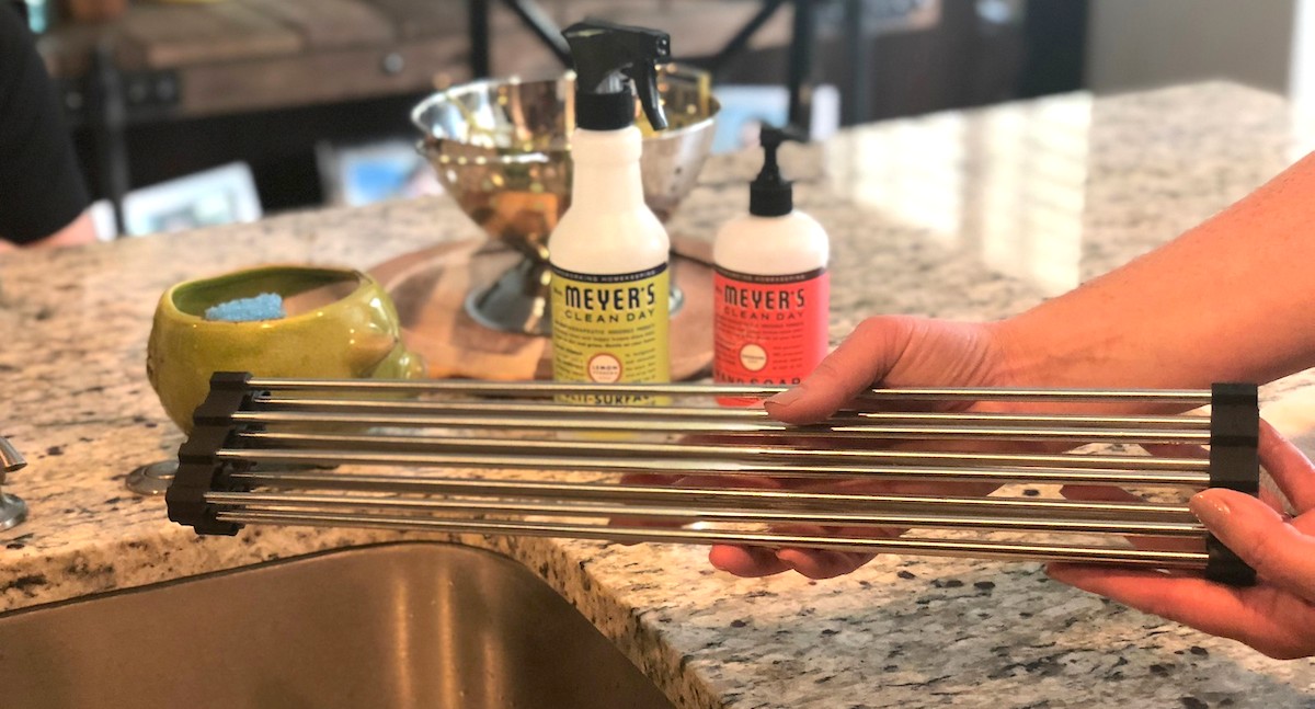 rolled up wire rod drying rack over kitchen sink with soap in the background