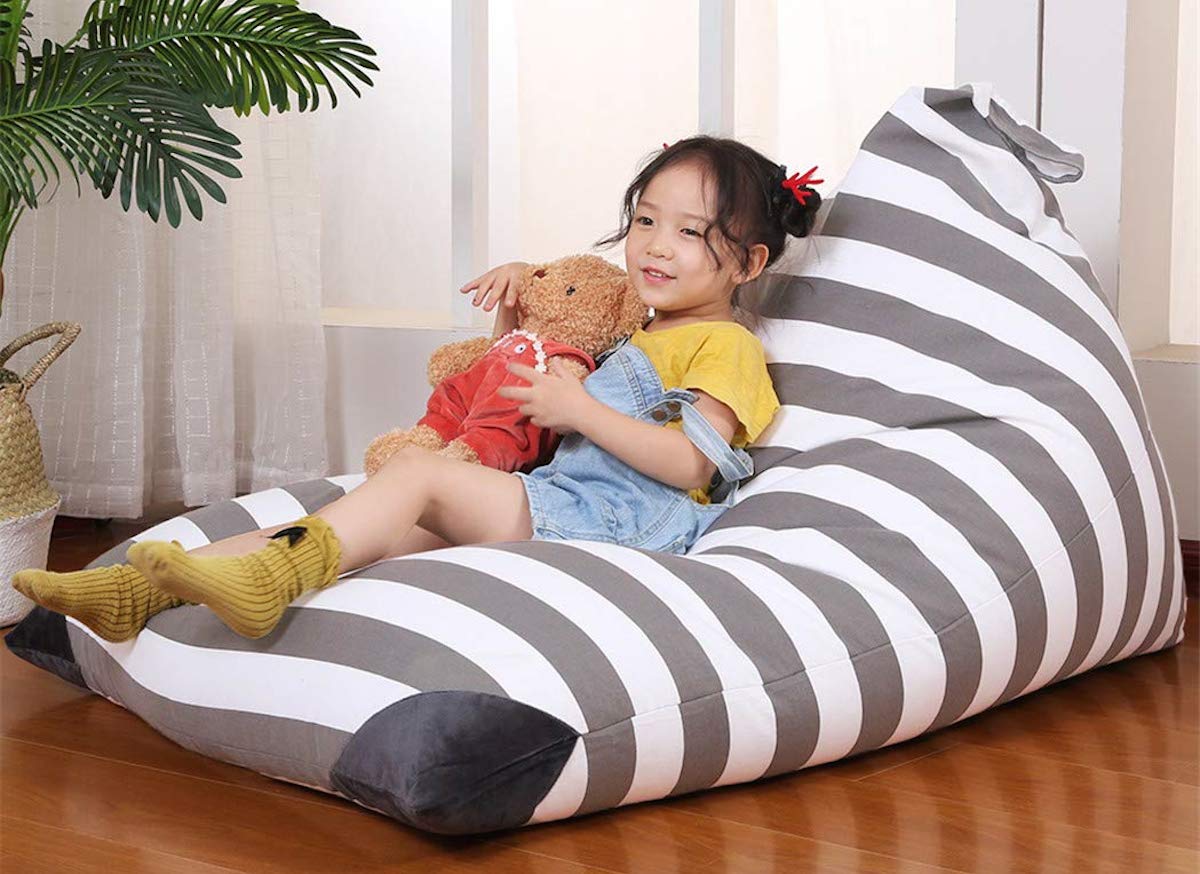 gray and white stripe bean bag chair with girl holding a stuffed bear