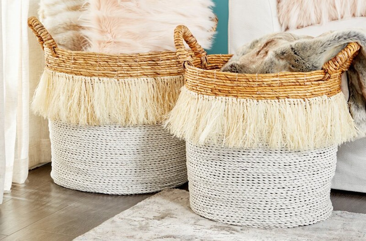 white yellow fringe two tone baskets on floor with pillows and blankets inside
