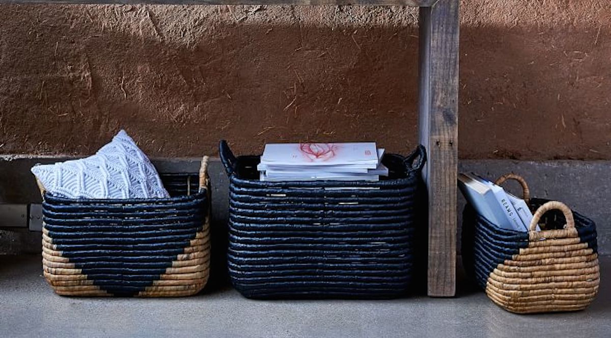 black and natural colored woven baskets sitting with magazines