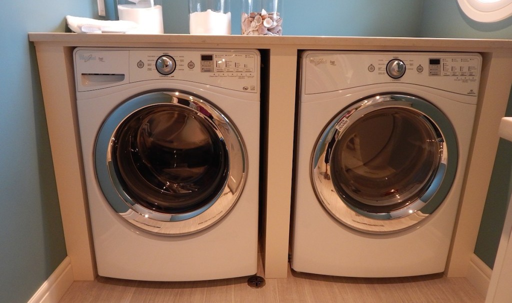 side by side front loading washer and dryer machines in laundry room