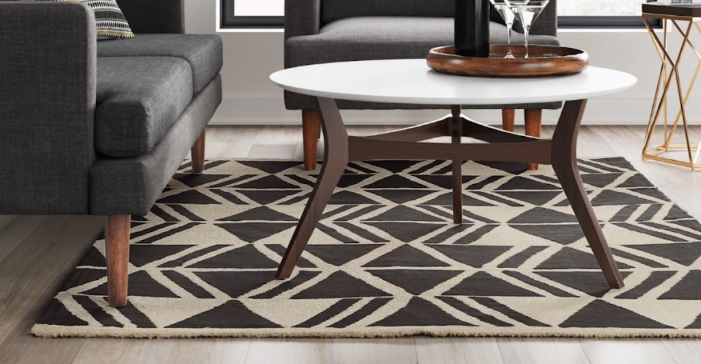 white and black geometric rug on wood floor with modern furniture