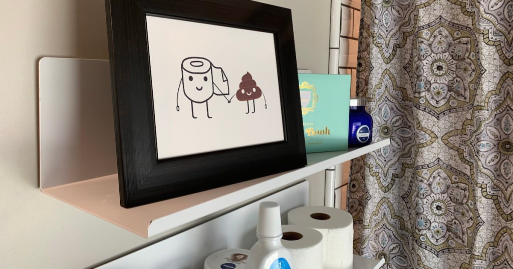 metal wall shelf in bathroom with toilet paper and poop emoji picture