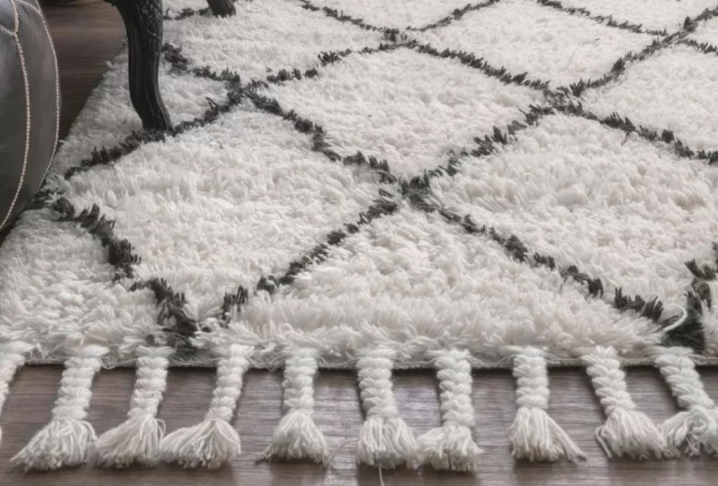white and black diamond shag rug on floor with braided tassels