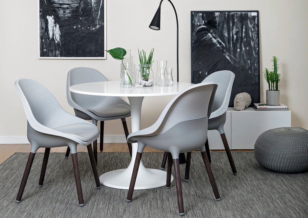 four gray modern chairs sitting at round white table 