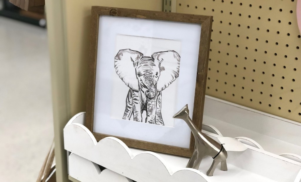elephant framed print on white scallop shelf with metal silver giraffe statue
