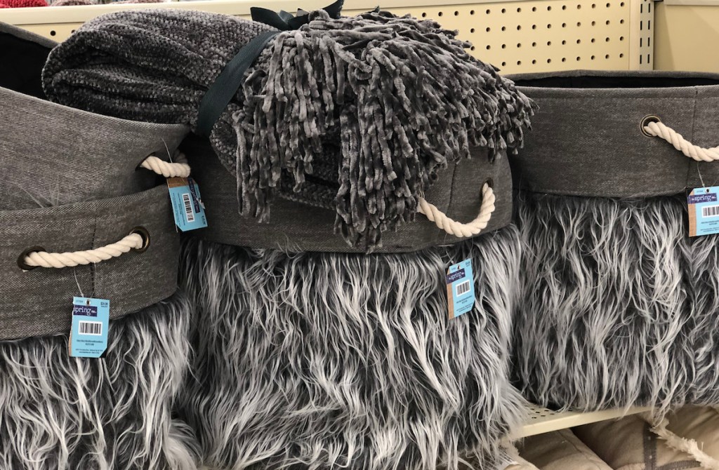 gray white faux fur baskets with gray blanket on top 