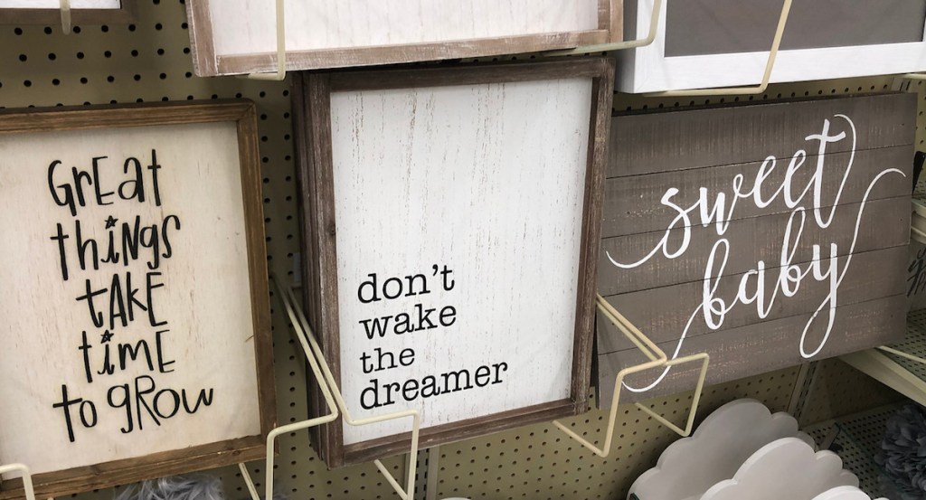 wooden print don't wake the dreamer hanging on shelf next to other wall decor