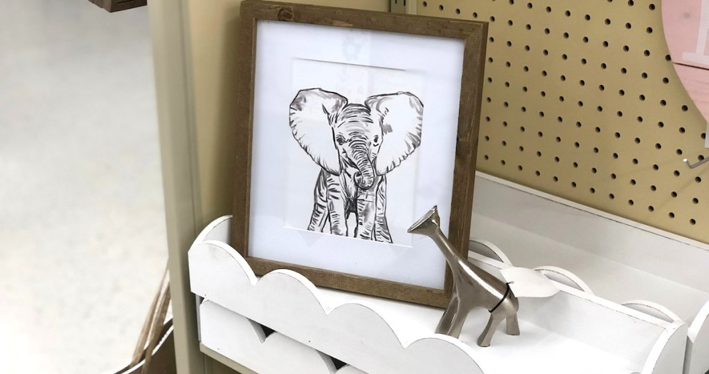 elephant picture sitting on white scalloped shelf with silver metal giraffe