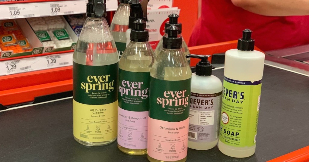 bottles of everspring cleaners and soaps next to mrs meyers soaps on store belt