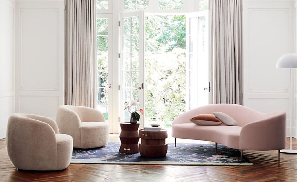 white chairs and pink sofa in a mid century modern and chic living area