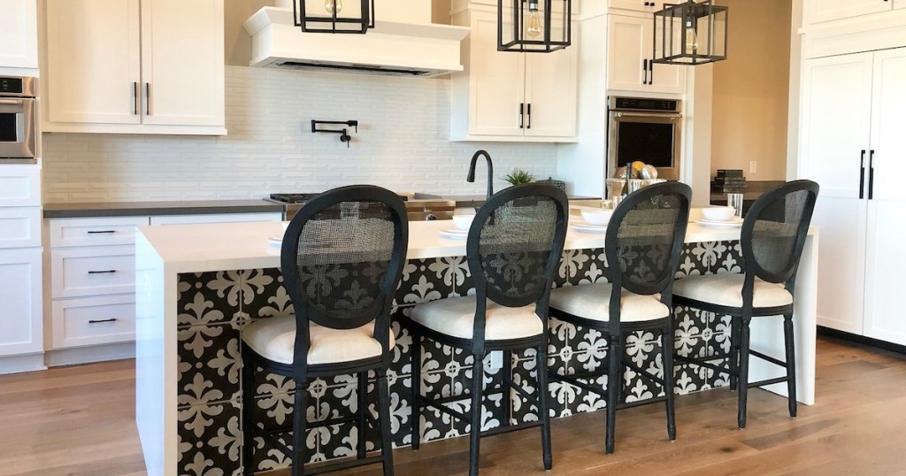 kitchen with white cabinets and black oval stools 