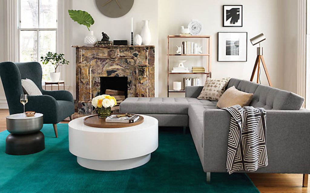 modern living room with white coffee table gray couch and teal colored rug