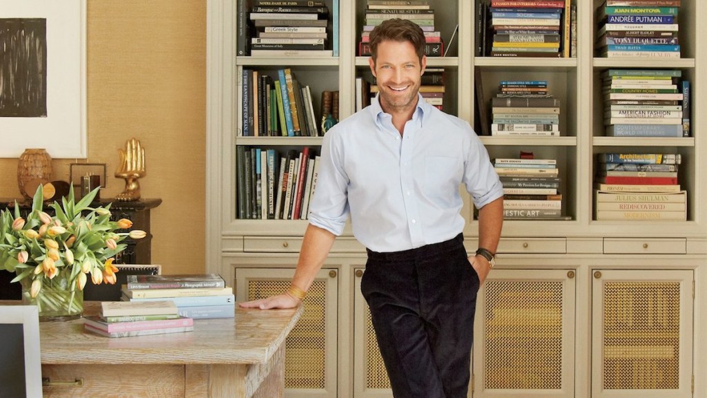 nate berkus standing in front of home library with tons of book