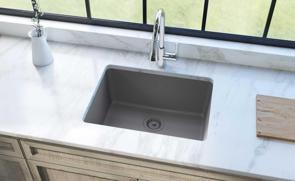 gray colored undermount sink with chrome faucet marble countertops and beige cabinets