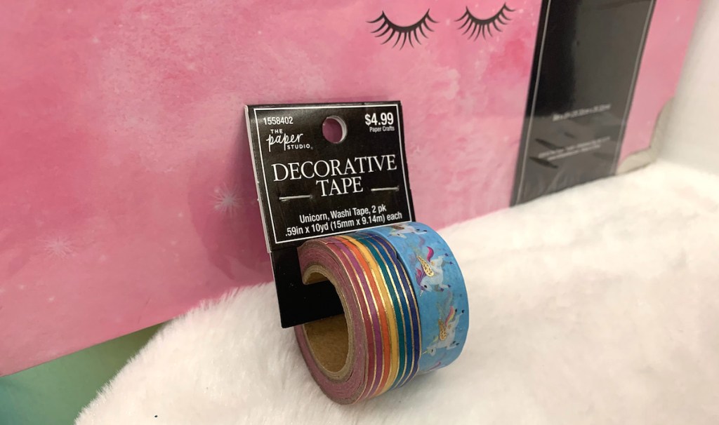 rainbow and gold tape roll with unicorn tape sitting on white fur table