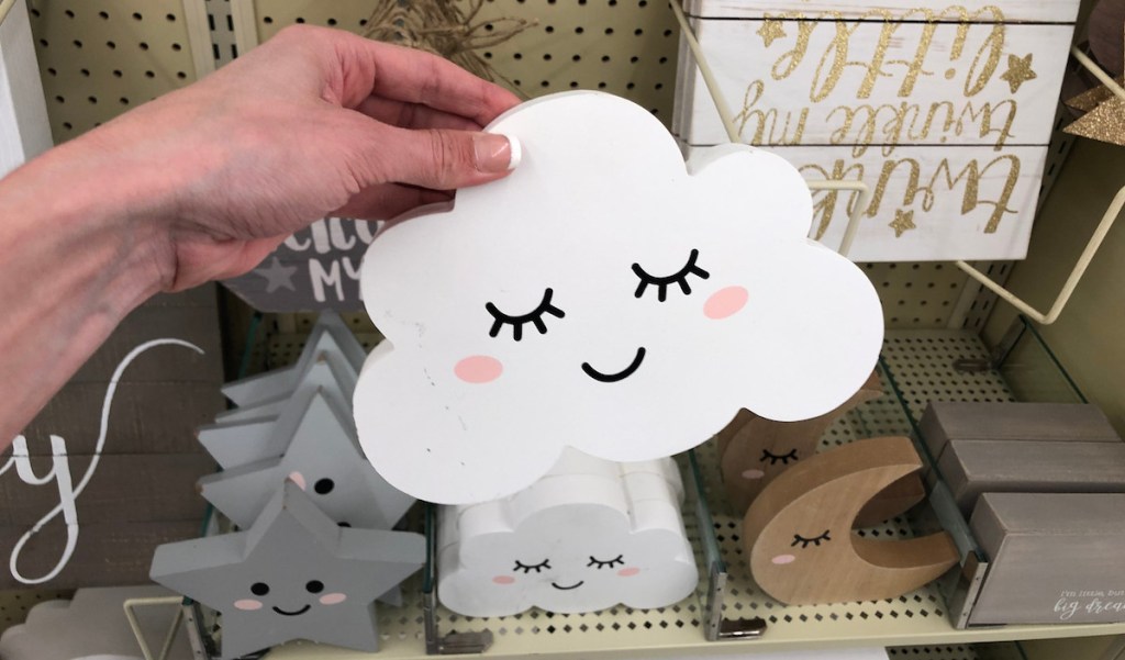 hand holding a white sleeping cloud with neutral decor in background