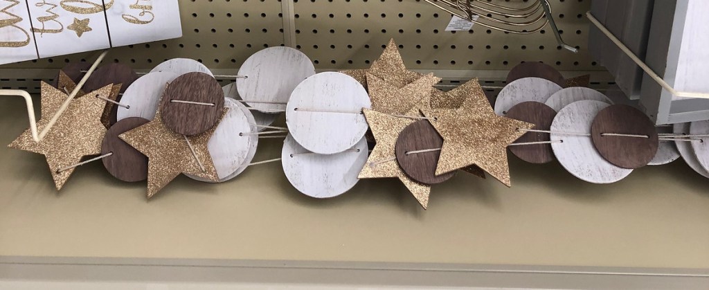 brown gold and white star and circle shaped banner garland laying on store shelf