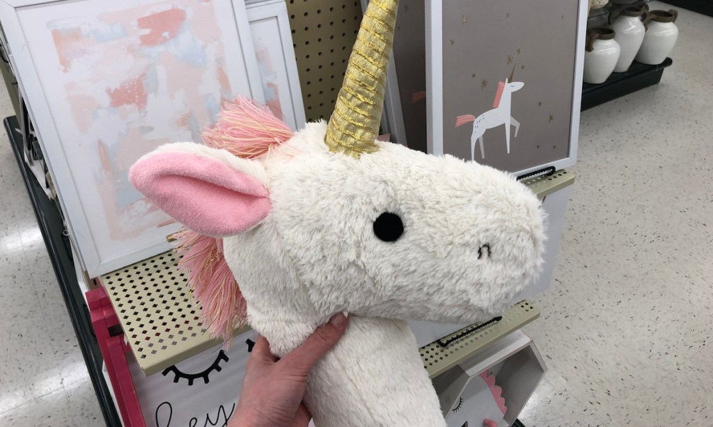 hand holding a plush unicorn white pink and gold