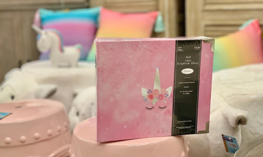pink unicorn scrapbook with rainbow pillows behind it