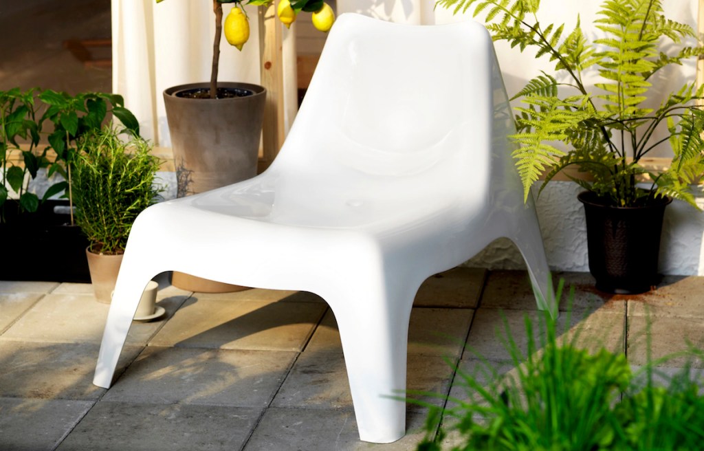 modern white plastic chair sitting outside with lemon tree hanging over it