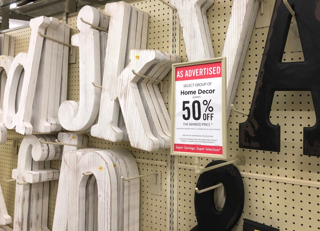 whitewashed distressed wood letters hanging on store peg board