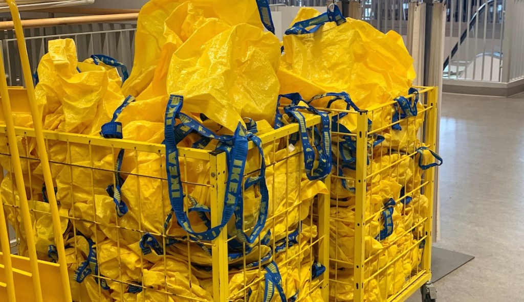 yellow reusable ikea bags with blue handles sitting in a large yellow bin