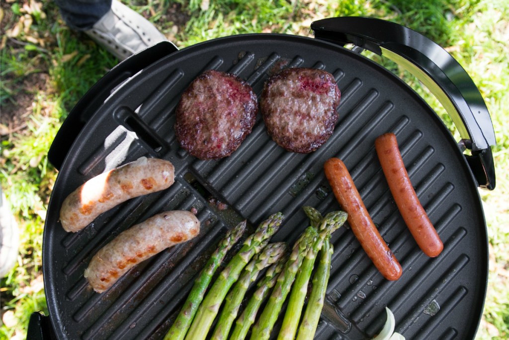 George Foreman grill with meats and veggies on it