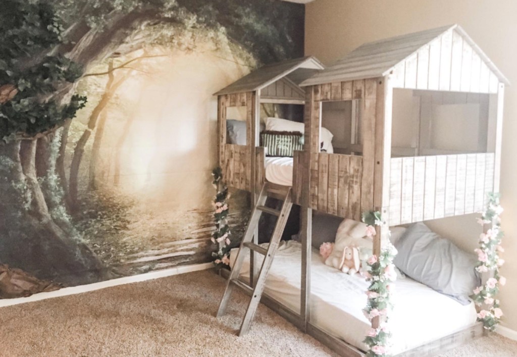wood bunk bed with roof and forest mural on wall