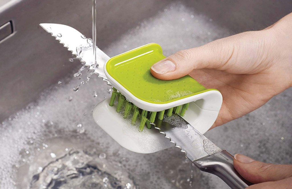 green brush cleaner washing sharp knife in sink