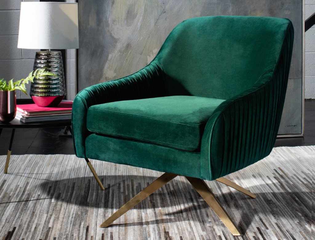 emerald green swivel chair on industrial gray cowhide rug with lamp and side table in background