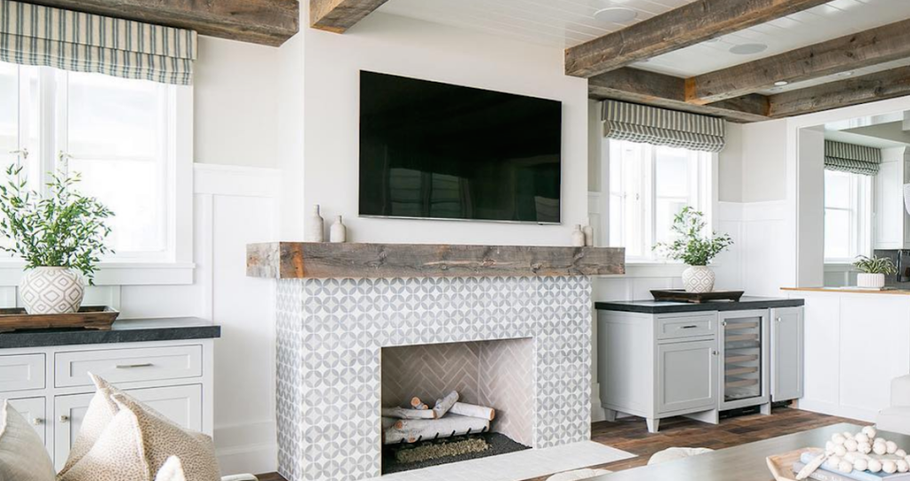 black TV over fireplace with salvaged wood mantel and decor