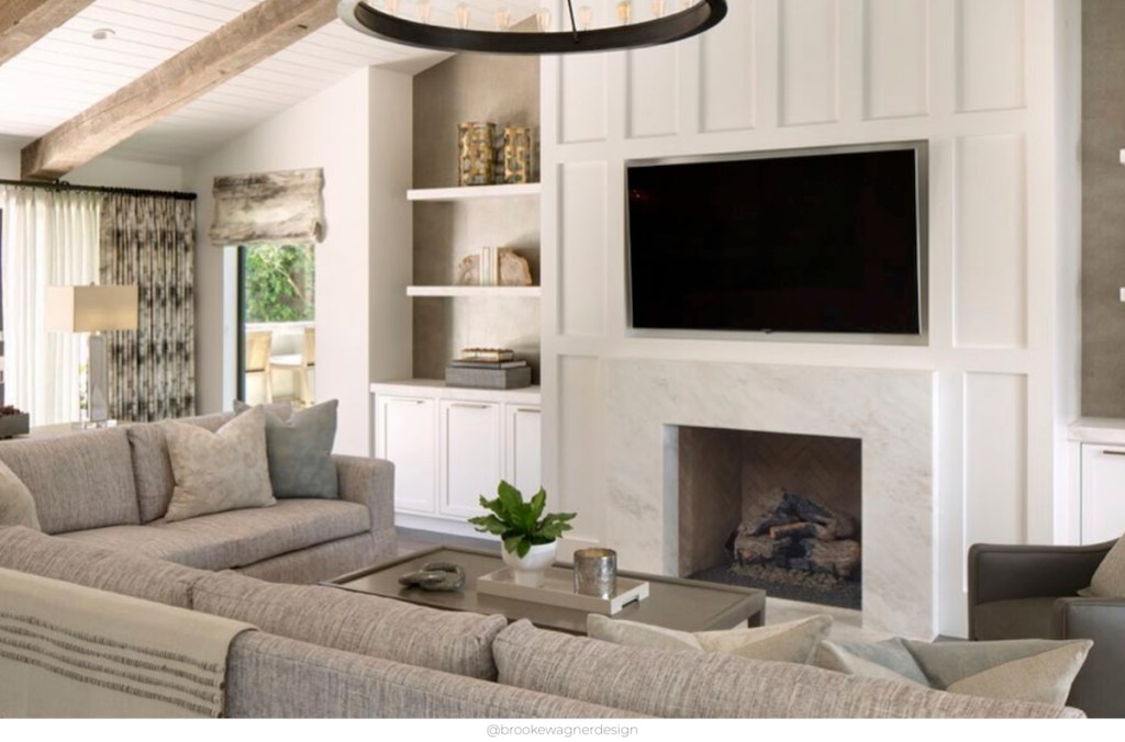 white board and battan fireplace with tv over top with large gray sectional