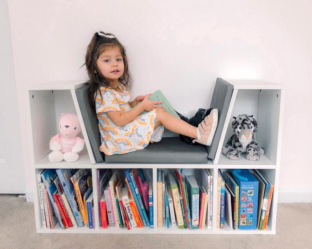 little girl sitting in 6-Cubbie Kids Bookcase w/ Reading Nook