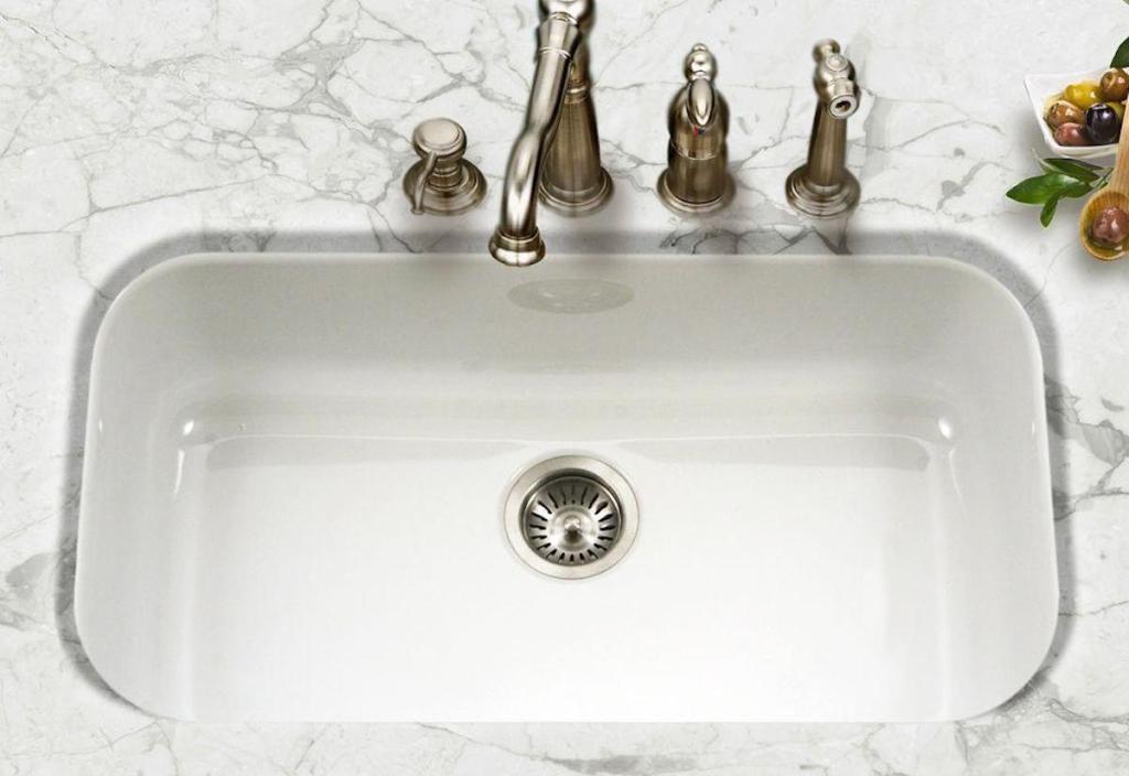 white glossy sink with stainless steel faucet and marble countertops