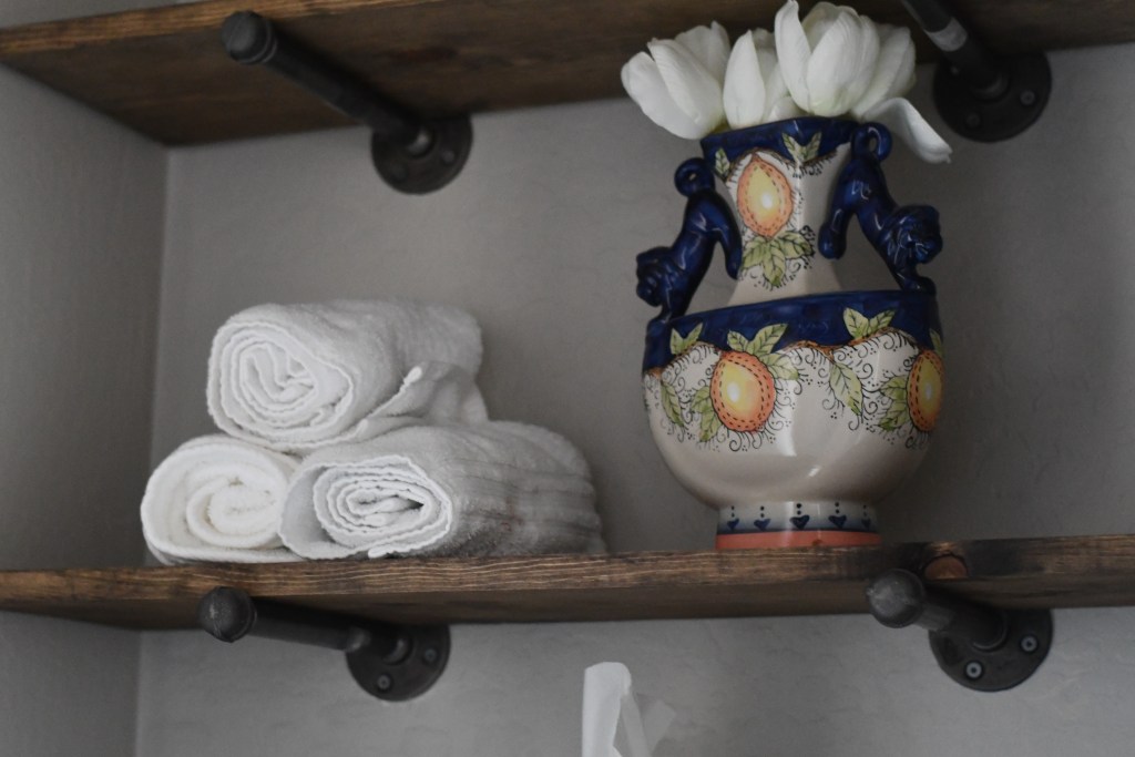 rustic open shelves with vase and towels 