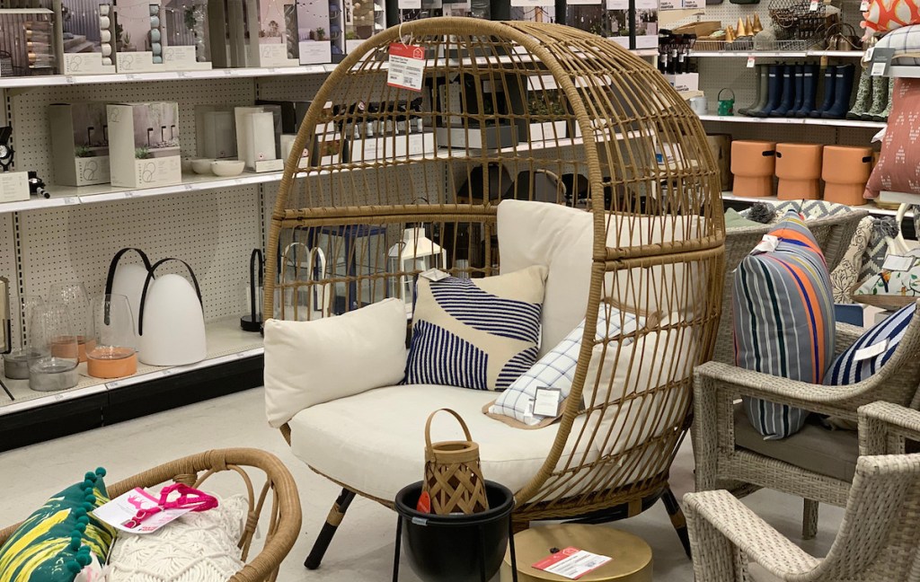 egg chair with white cushions and pillows sitting in store