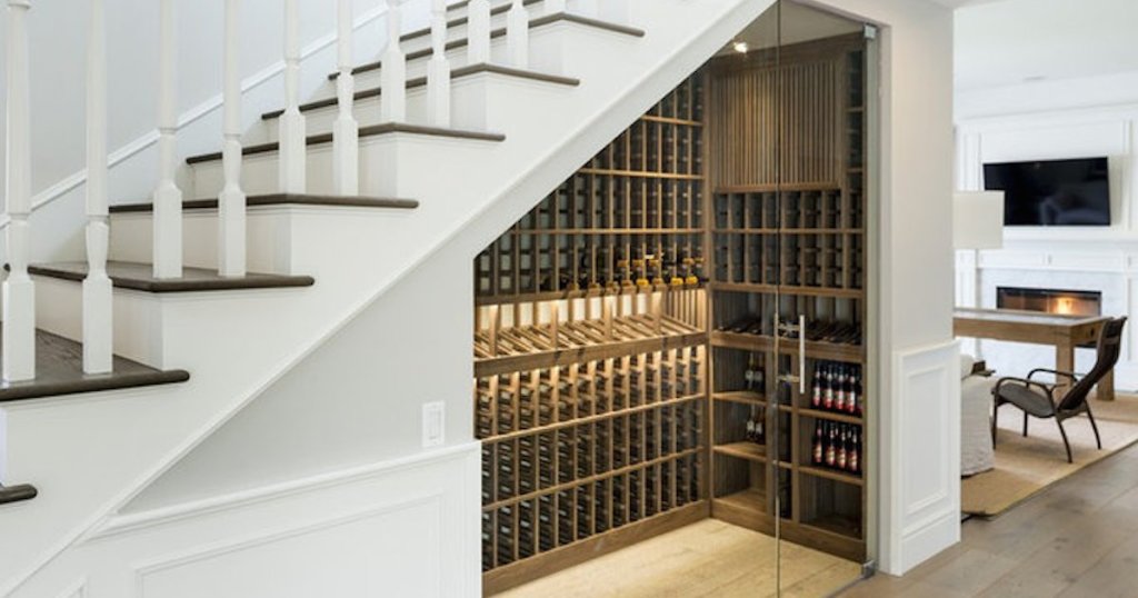 wine cellar under white and brown wood staircase with fireplace and TV mounted on wall in background