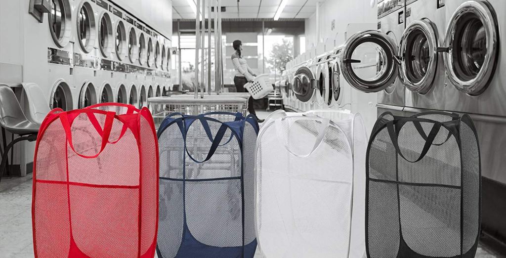 four different colored hampers at a laundry mat