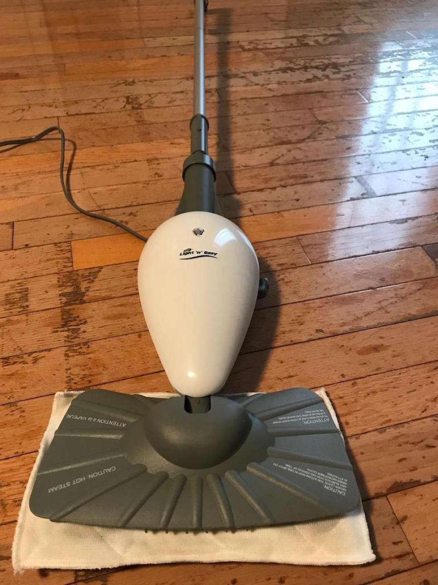 steam mop laying on hardwood floors 